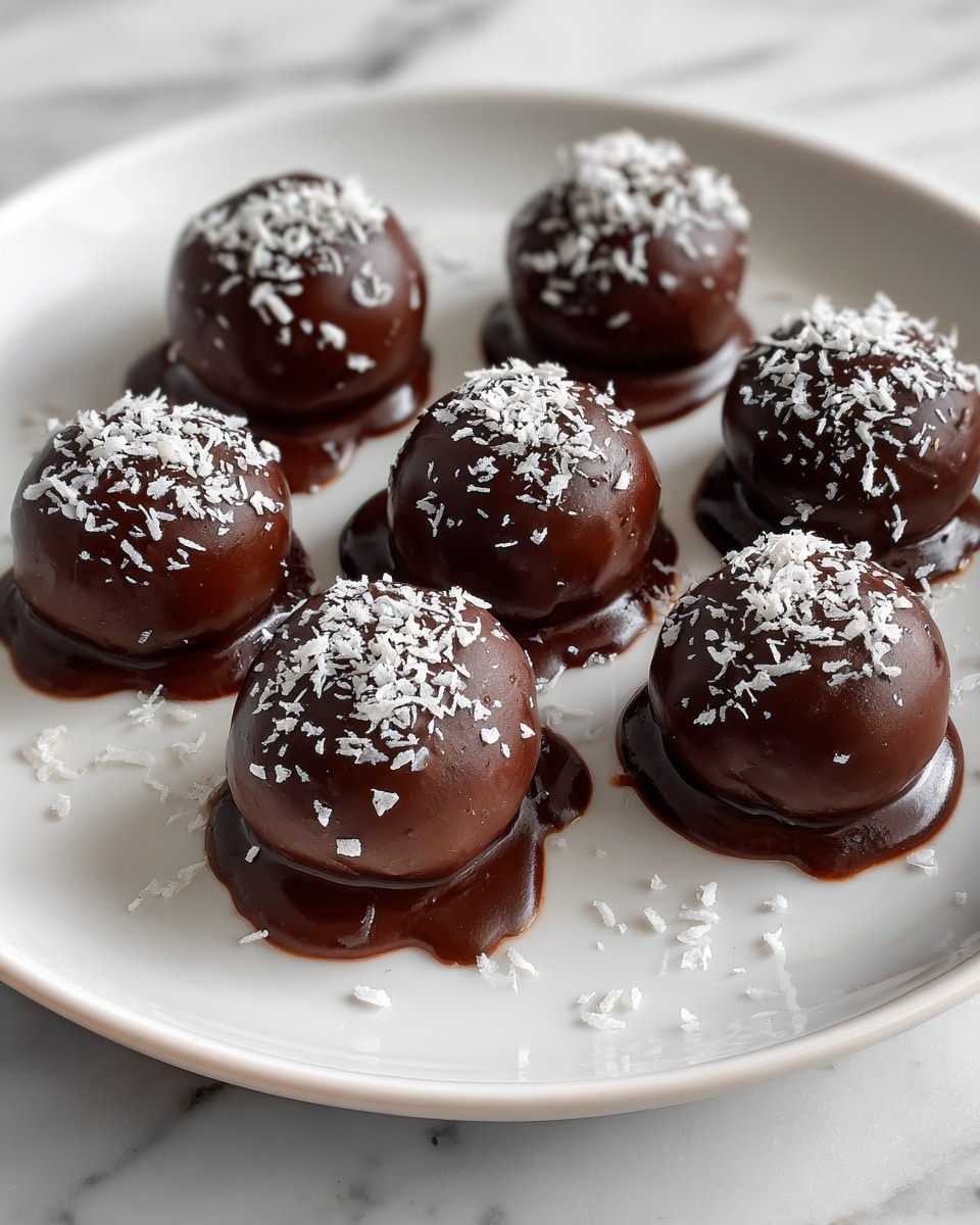Round chocolate balls are spread out on a white plate with a white marbled background. Each ball is coated with a thick, shiny layer of dark brown chocolate that has some folds and uneven swirls. On top, small white flakes are sprinkled for decoration. Some chocolate drips slightly at the base of a few balls, giving a smooth but imperfect texture to the coating. The balls are arranged loosely, with space between them, showing bits of the white plate beneath. photo taken with an iphone --ar 4:5 --v 7