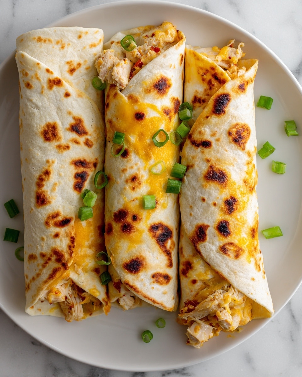 The image shows three grilled wraps placed close together on a white plate over a white marbled surface. Each wrap has an outer layer of tortilla marked with dark brown grill spots, giving a textured look. Inside, the layers are filled with melted bright orange cheese and small pieces of cooked white chicken. There are small green onion pieces and slices of red chili scattered on top and around the wraps, adding pops of green and red color. The wraps are rolled tightly with the filling slightly visible at the ends, showing a mix of creamy, juicy, and slightly charred textures. Photo taken with an iphone --ar 4:5 --v 7