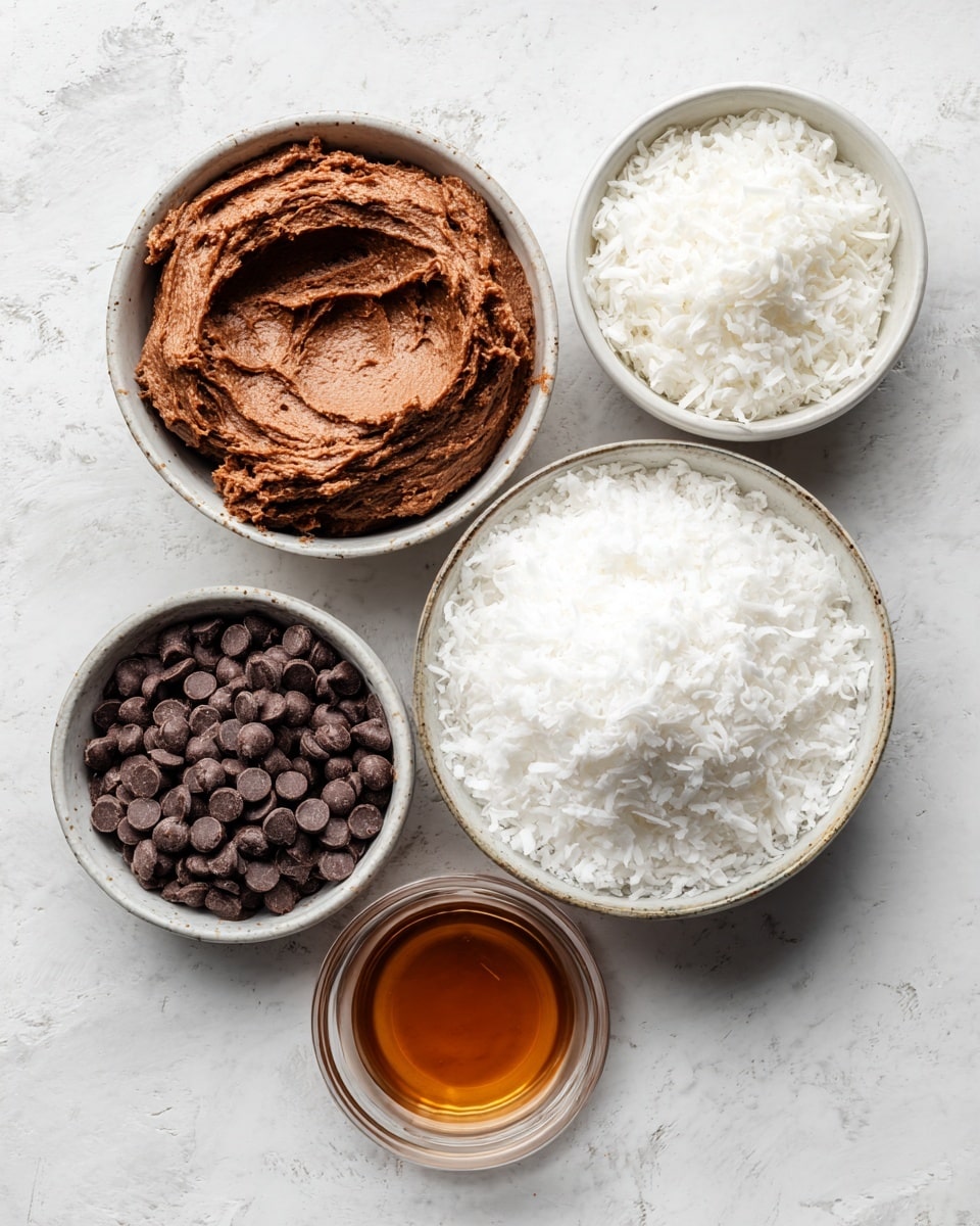 Five clear round glass bowls are arranged on a white marbled surface; the largest bowl on the right is filled with fluffy white shredded coconut, above it a smaller bowl also holds white shredded coconut but in a smaller amount. On the left side, a large bowl contains a thick, rough-textured brown paste, below it another bowl is filled with dark chocolate chips which are round and smooth. At the bottom right corner, the smallest bowl holds a smooth amber-colored liquid. Photo taken with an iphone --ar 4:5 --v 7