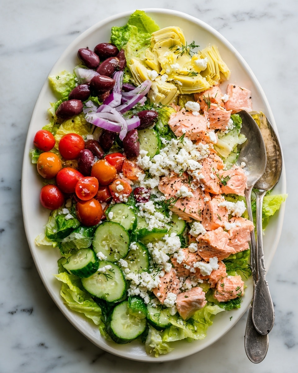 A white oval plate holds a colorful layered salad on a white marbled surface. The bottom layer is bright green romaine lettuce leaves. On top, there are light pink pieces of cooked salmon spread across the center. Around the salmon, there are several pale yellow artichoke hearts, dark purple Kalamata olives, and sliced green cucumbers with a shiny, moist texture. Bright red halved cherry tomatoes add a pop of color throughout. The dish is topped generously with crumbled white feta cheese and a light sprinkle of black pepper. A shiny spoon is placed on the right side of the plate. Photo taken with an iphone --ar 4:5 --v 7